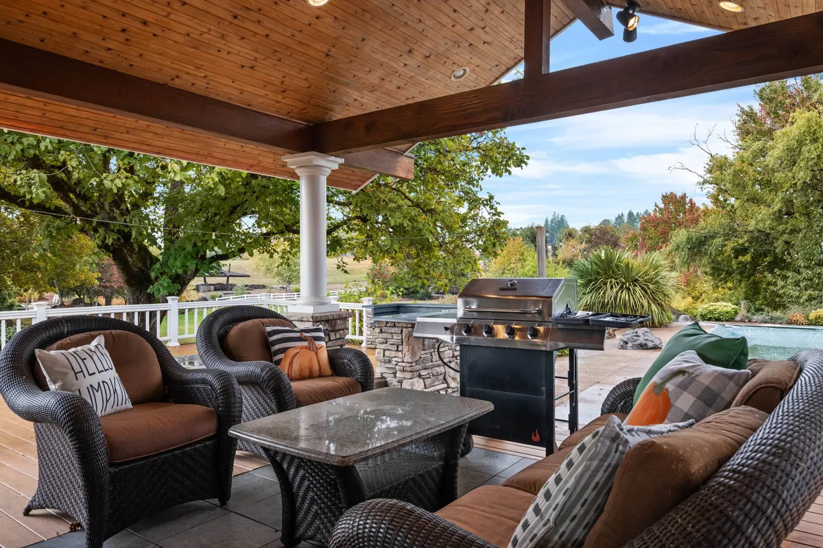 This image showcases a spacious outdoor seating area complete with a grill and sweeping landscape views, ideal for enjoying meals or socializing outside. The setup suggests the enjoyment of Oregon’s scenery and leisure activities, with plenty of natural light and open-air ambiance.