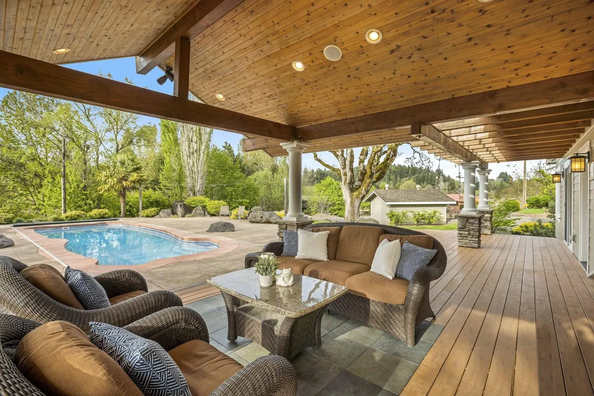 An inviting exterior scene showcasing the sparkling swimming pool, ample outdoor seating, and lush greenery surrounding the area. The sunset sky adds a tranquil ambiance, making it ideal for group gatherings and relaxation.